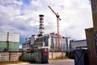 Строительный башенный кран на фоне саркофага, возведенного над 4-м блоком Чернобыльской АЭС
