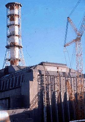 С близкого расстояния хорошо видно, что саркофаг, возведенный над 4-м блоком Чернобыльской АЭС, имеет весьма внушительные размеры и продолжает хранить в своем нутре грубую ядерную силу.